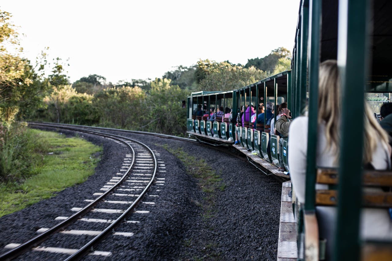services-03 A scenic train ride through lush greenery with passengers enjoying the view.