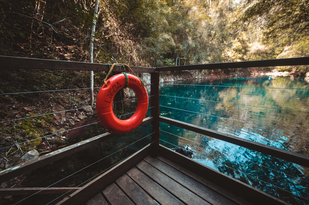 A serene view from a wooden deck overlooking Lagoa Misteriosa in Bonito, Brazil, with vibrant blue waters.